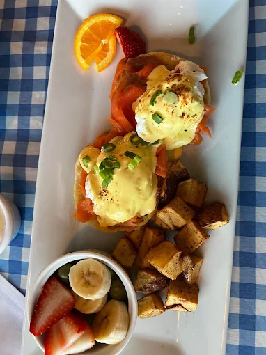 Fusion eggs Benedict with breakfast potatoes and fruit